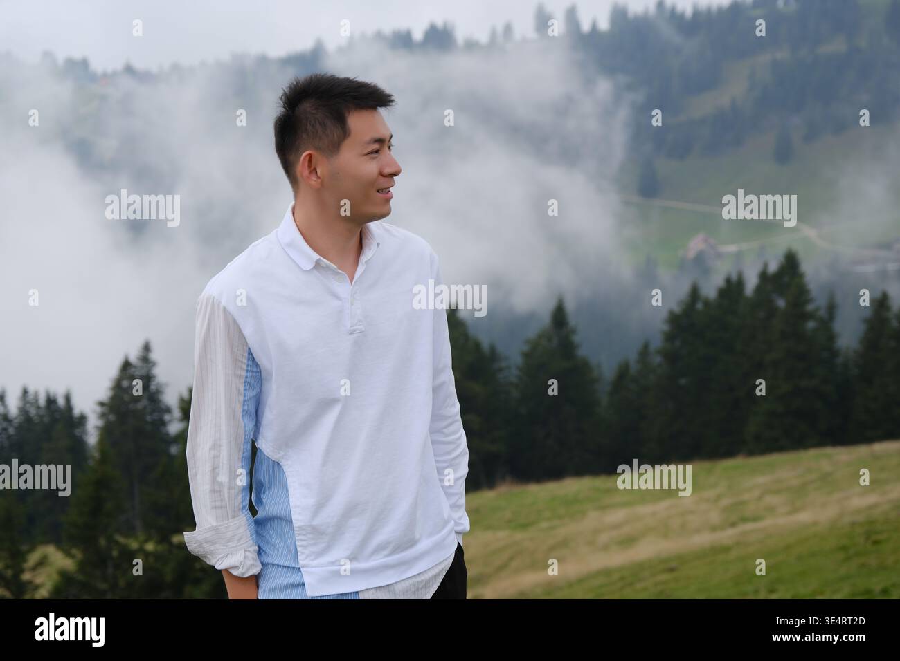 Asiatischer Mann seitlicher Blick auf den nebeligen Berg Rigi, Schweiz Stockfoto