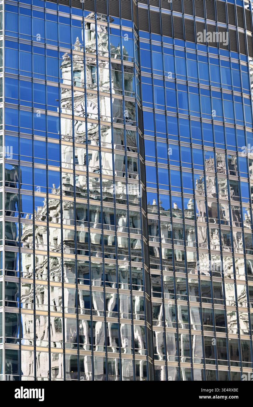Chicago, Illinois, USA. Das Wrigley Building mit seinem charakteristischen Uhrenturm spiegelt sich in einem Segment des nahegelegenen Trunp Tower wider. Stockfoto
