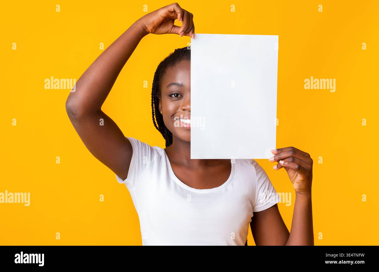 Schwarze Frau, die die Hälfte ihres Gesichts mit sauberem Papier bedeckt Stockfoto