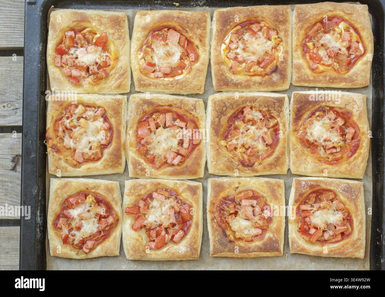Food, hausgemachte Pasteten aus Blaetterteig mit Tomate, Schinken und Kaese in der Pfanne. Mini-Pizza Stockfoto