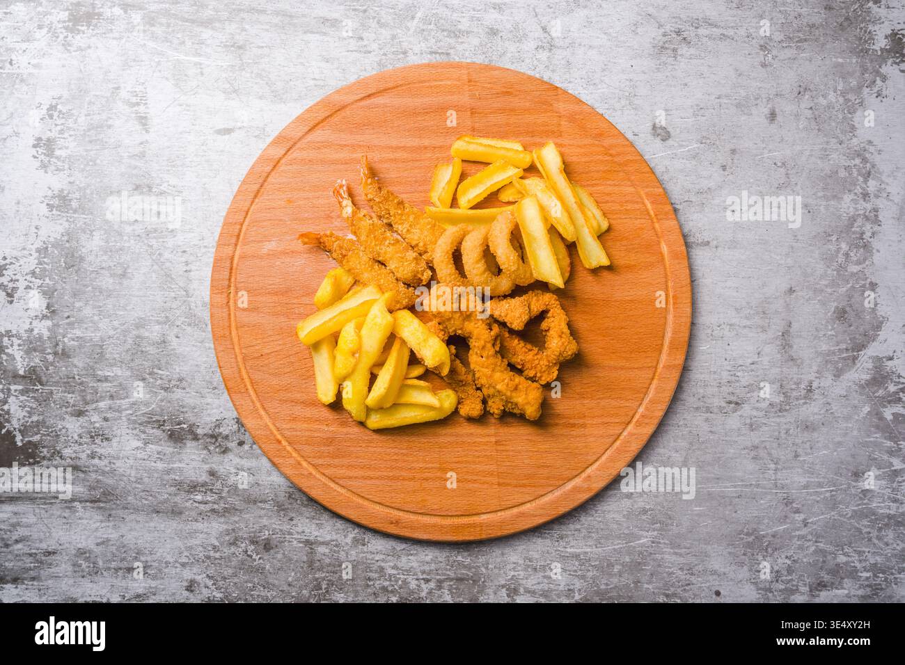 Blick von oben auf gebratene Hähnchennuggets, Garnelen-Zwiebelringe und Pommes frites Stockfoto