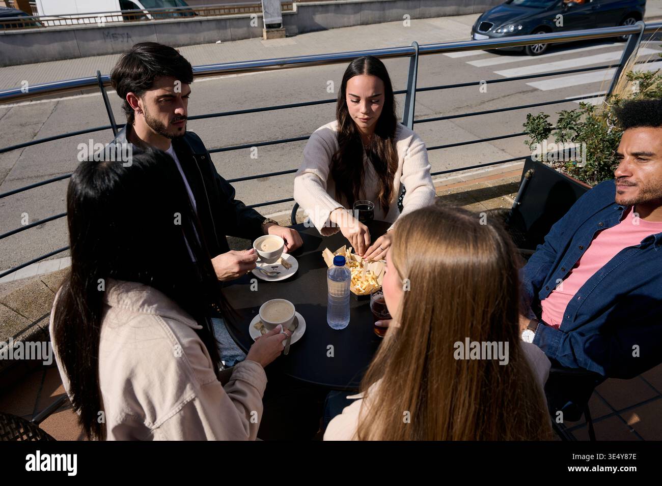 Junge Freunde genießen Kaffee und Snacks im Café im Freien Stockfoto