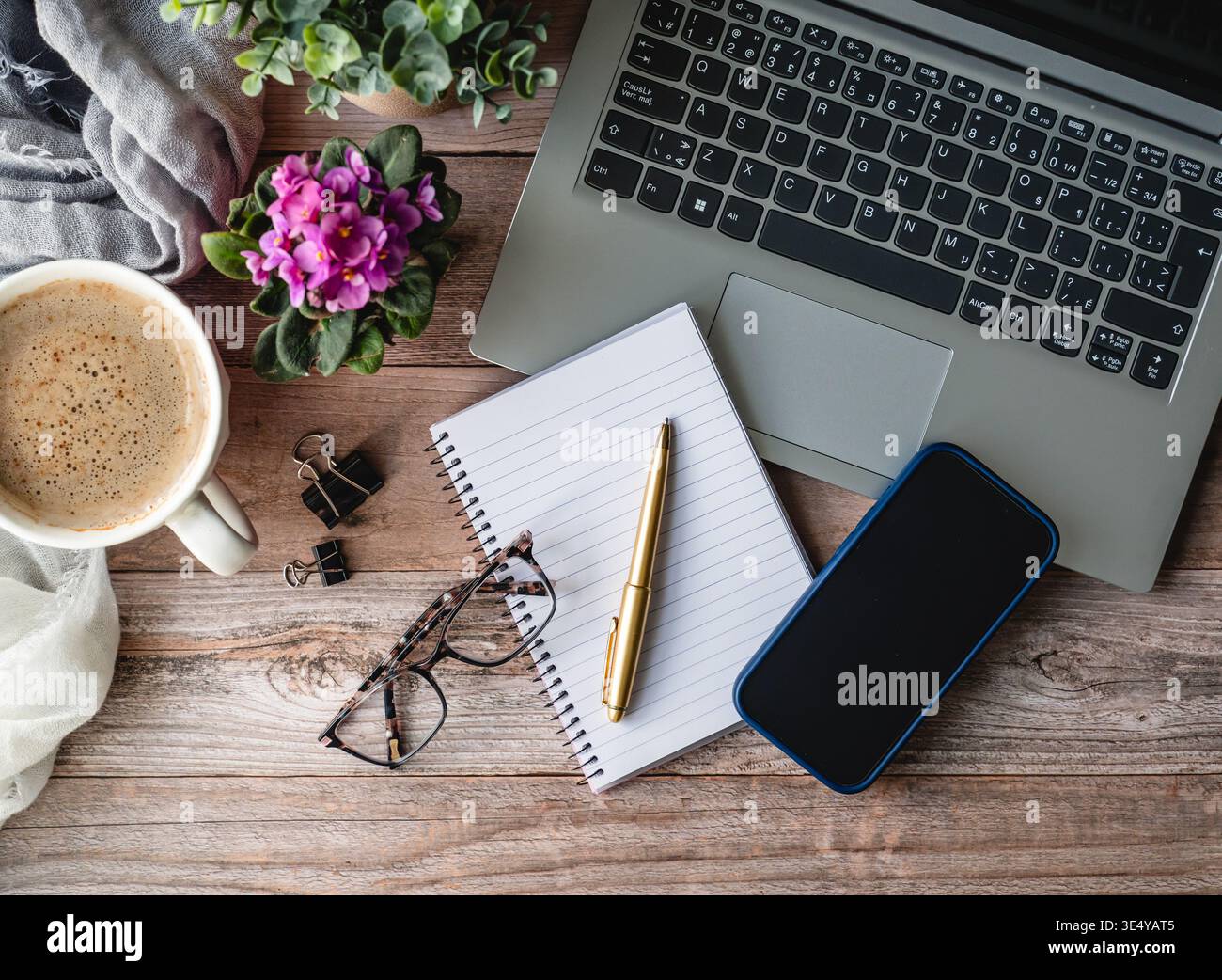 Draufsicht auf die Arbeitsszene mit Computer, Telefon, Kaffee, Notizblock. Stockfoto