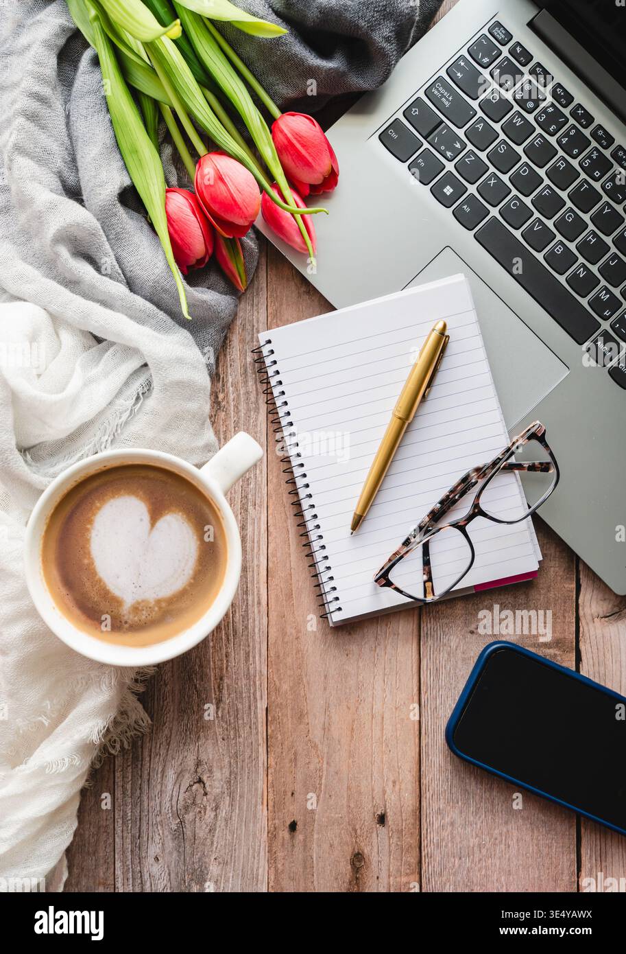 Draufsicht auf die Arbeitsszene mit Computer, Telefon, Kaffee, Notizblock. Stockfoto
