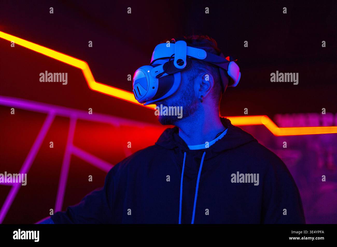 Schöner Mann mit Virtual-Reality-Headset mit Neonlicht. VR, Zukunft, Gadgets, Technologie, Online-Bildung, studieren, Videospielkonzept Stockfoto