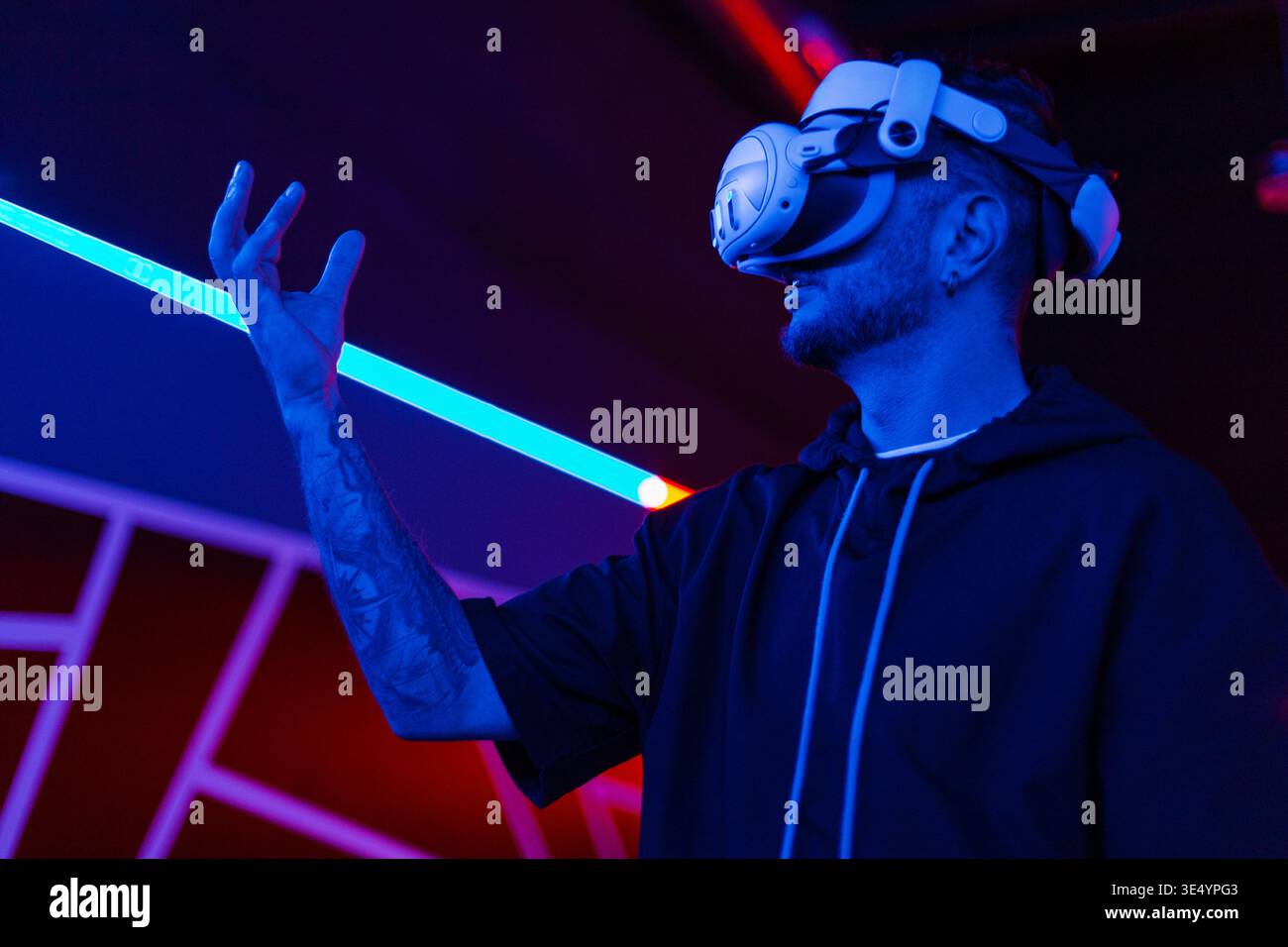Fantastische Technologie, Online-Spiele, Unterhaltung, Studium und virtuelle Welt in 3D-Simulation. Seriöser Millennial-Mann mit vr-Brille spielt und versucht zu berühren Stockfoto