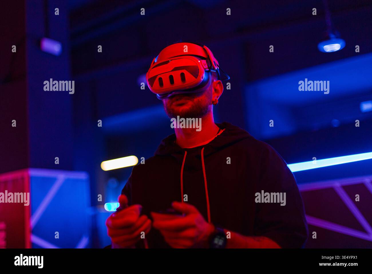Coole Techniker mit VR-Headset-Brille steuert virtuelles Menü in dunklen Räumen mit Neonlicht Stockfoto