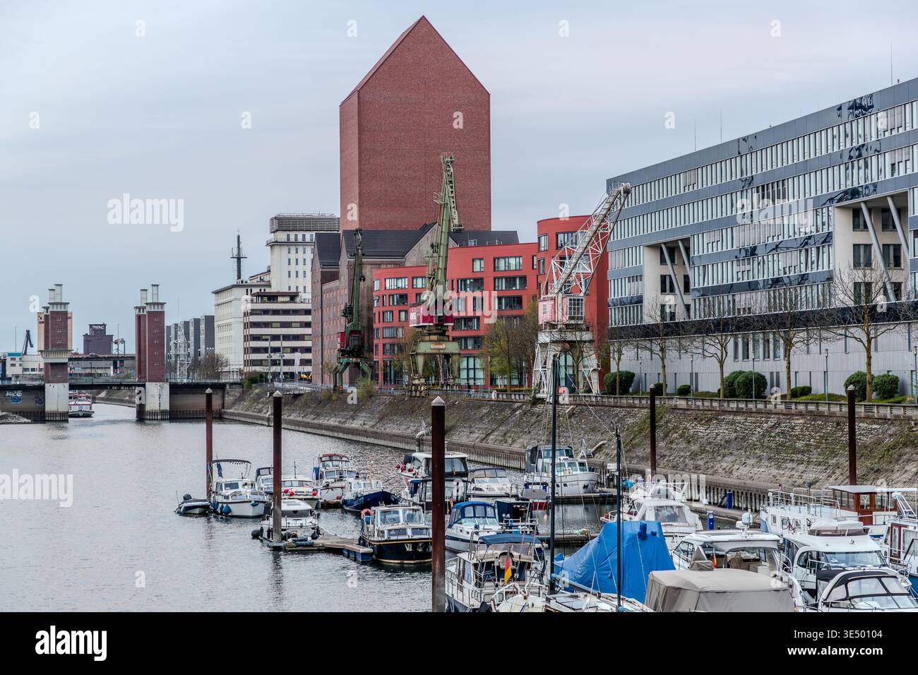 Duisburger Innenhafen mit dem Staatsarchiv NRW. Der Komplex entstand ab 2008 durch den Umbau eines historischen Lagerhauses. Die Neuentwicklung kombiniert das denkmalgeschützte Lager aus dem Jahr 1936 mit einem 77 Meter hohen Archivturm und einer 160 Meter langen, wellenförmigen, orangefarbenen Erweiterung. Duisburg, Nordrhein-Westfalen, Deutschland Stockfoto
