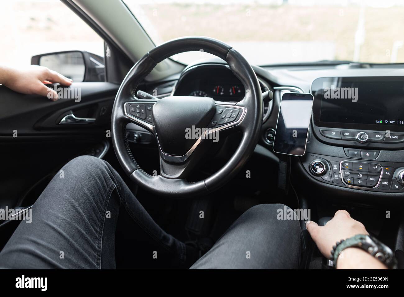 Der Mann sitzt in einem Auto und ruht sich aus. Mieten Sie ein Auto. Probefahrt Stockfoto