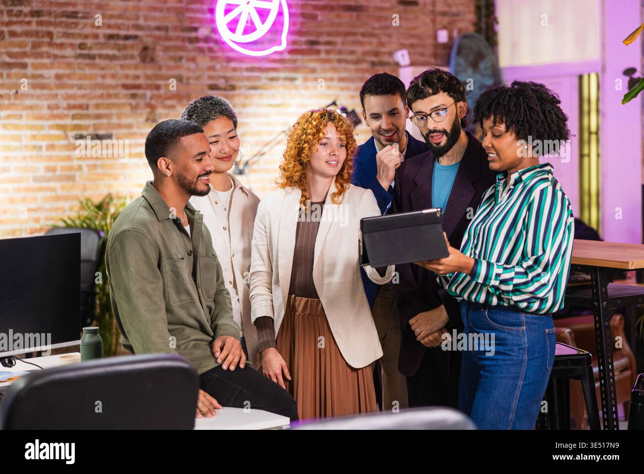 Multiethnische Teams arbeiten gemeinsam an einem digitalen Tablet in modernen Büros Stockfoto