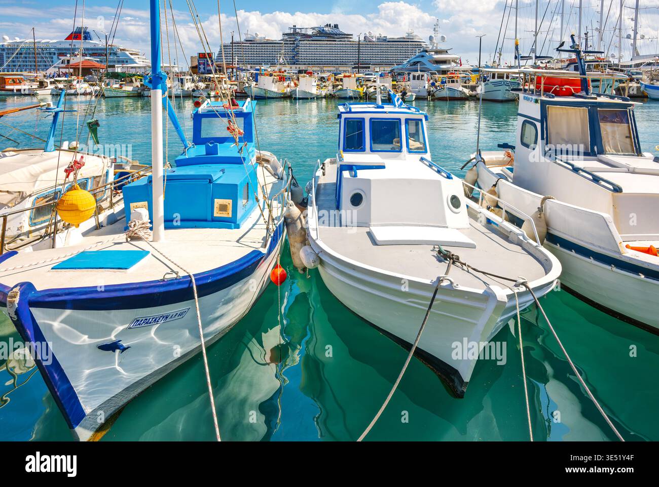 Fischerboote und Kreuzfahrtschiffe säumen den Hafen und Hafen von Mandraki in der mittelalterlichen Küstenstadt Rhodos, Griechenland, auf der Insel Rhodos. Stockfoto