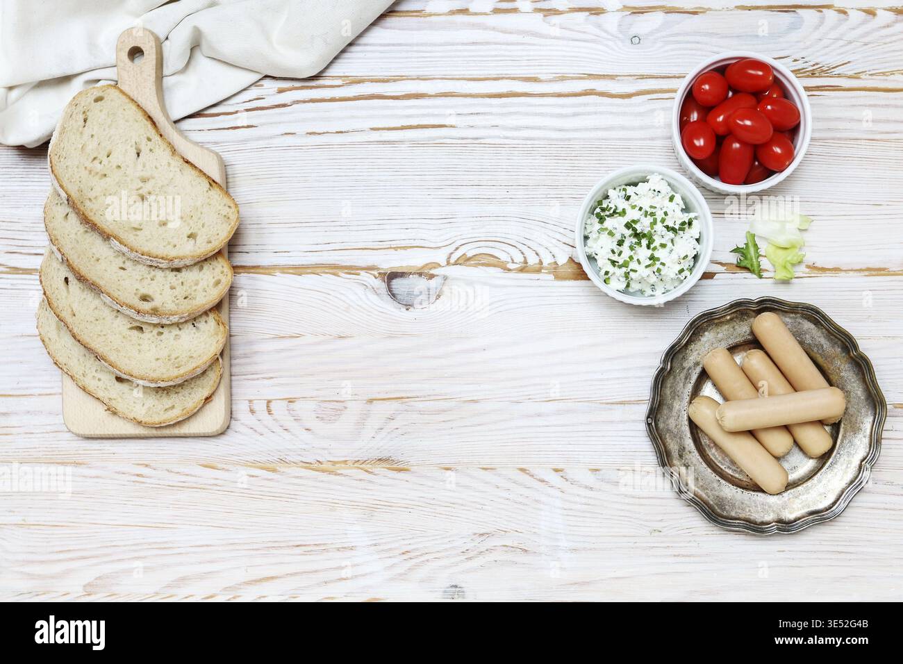 Frühstückstisch mit Hütte, Würstchen und Tomaten. Kopierraum, Holzhintergrund. Stockfoto