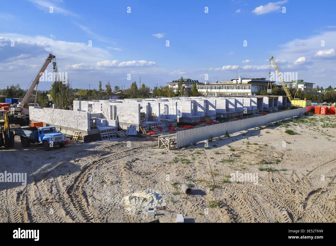 Das Bild zeigt eine Baustelle und zeigt Strukturen in Bearbeitung, Kräne und Ausrüstung an einem klaren Himmel Stockfoto