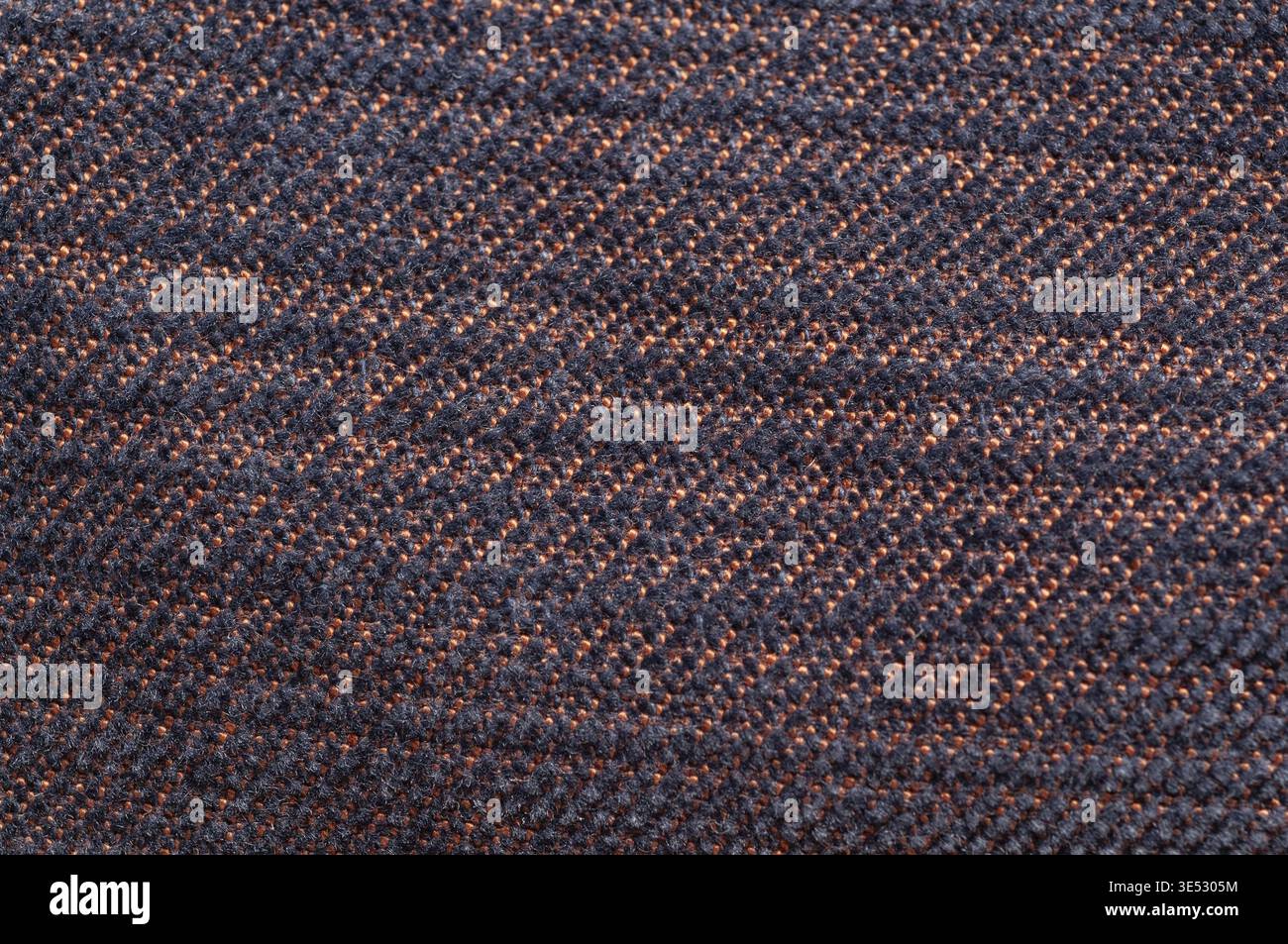 Dieser detailreiche Stoff zeigt eine gewebte Textur mit einem sich wiederholenden Muster, perfekt für Hintergründe und Designelemente Stockfoto