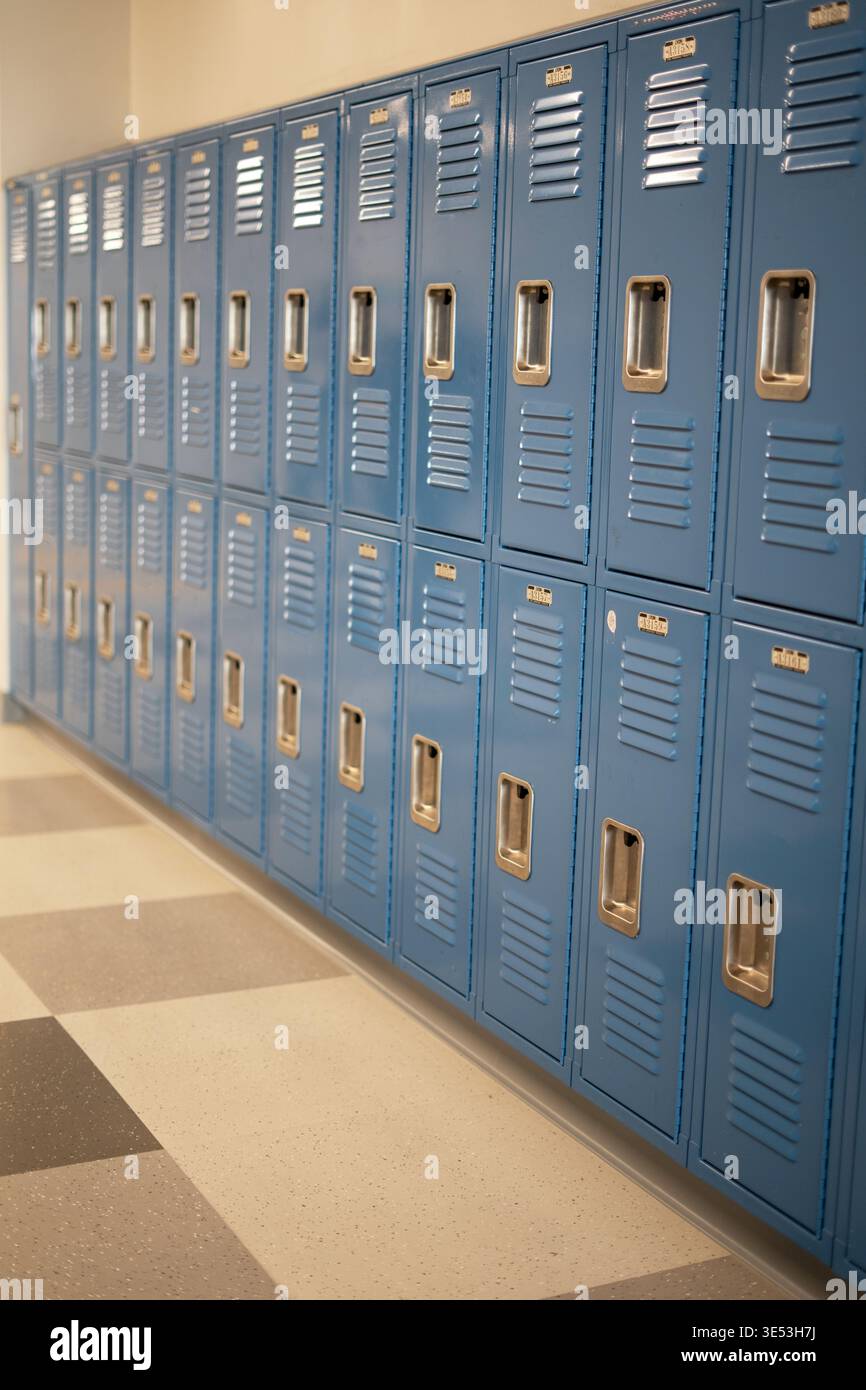 Reihe blauer Schulschränke im Flur mit perspektivischem Blick. Sauberer Bildungshintergrund mit Kopierraum und ohne Leute. Stockfoto