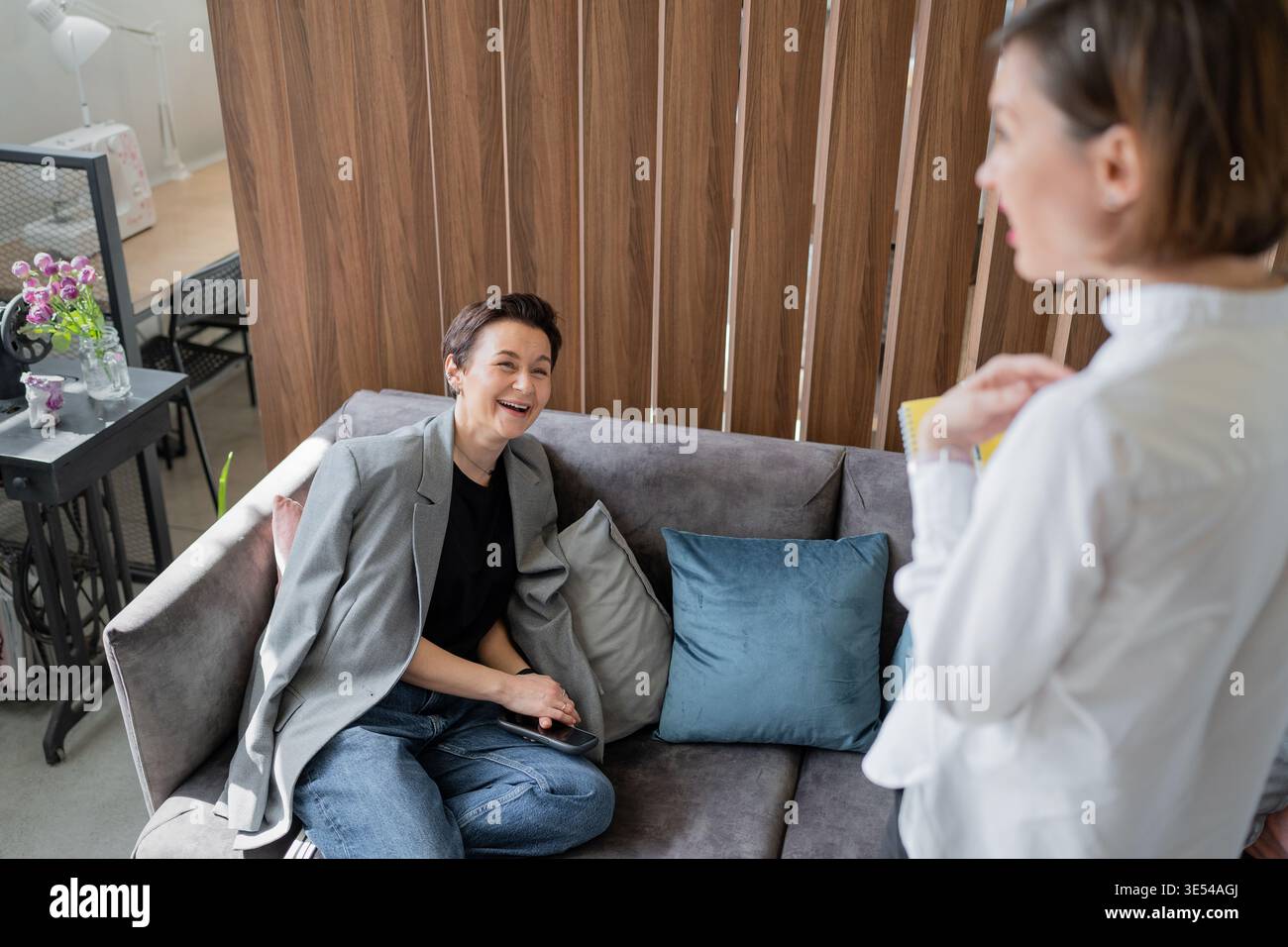 Weibliche Kollegen, die sich in entspannter Büroumgebung auf dem Sofa ausruhen und unterhalten. Entspannt, Gespräch, Kollegen, Sofa, Büro, Teamwork. Stockfoto