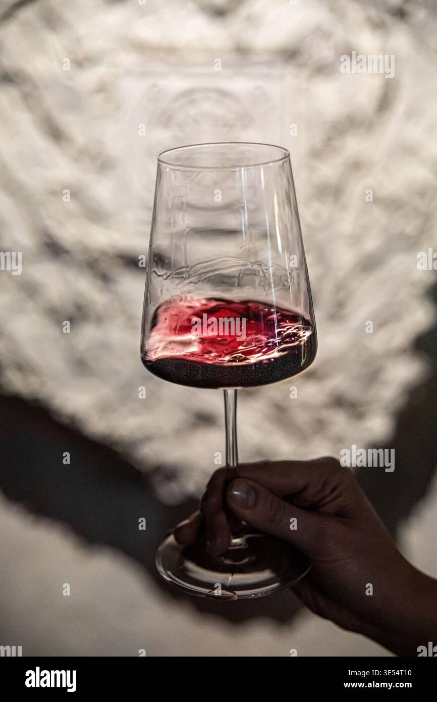 Wirbelnder Rotwein im Glas, von Hand gehalten Stockfoto
