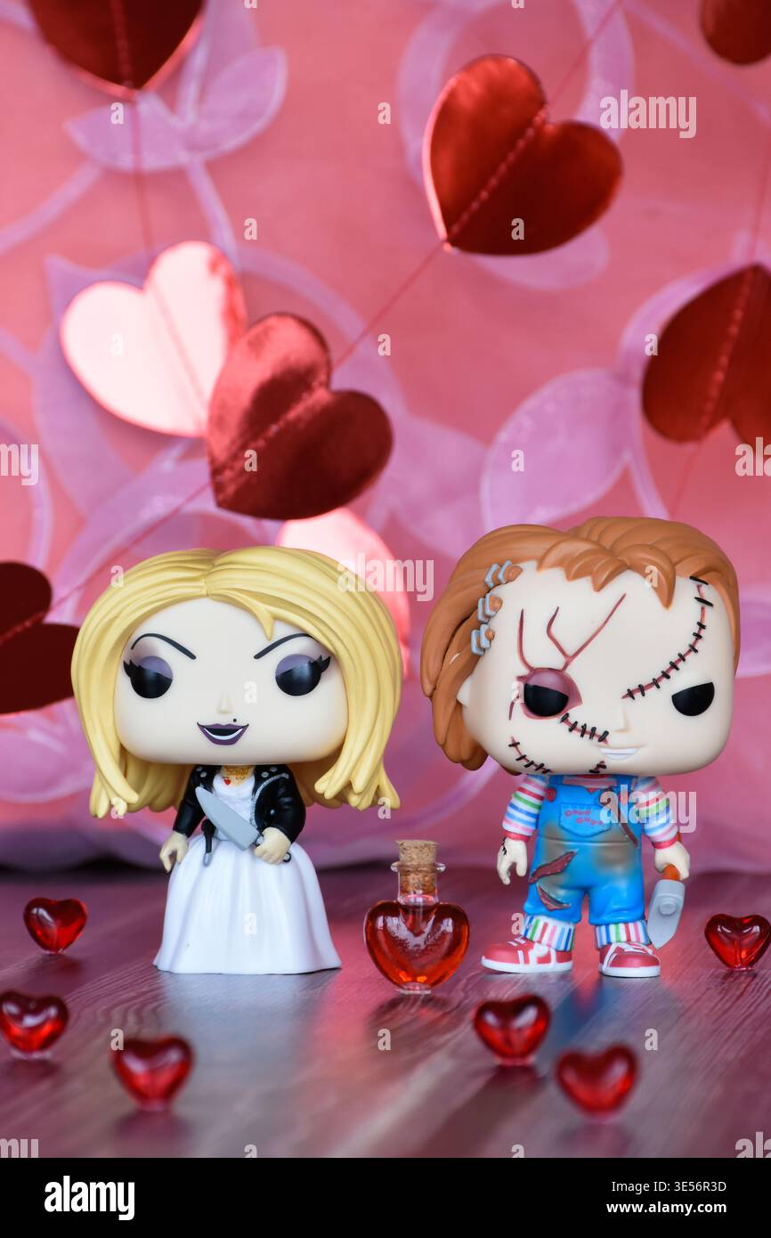 Funko Pop Actionfiguren der Killerpuppen Chucky und Tiffany. Valentinstag, rote Papierherzen, Glasherzen, Mini-Love-Trank-Flasche. Stockfoto