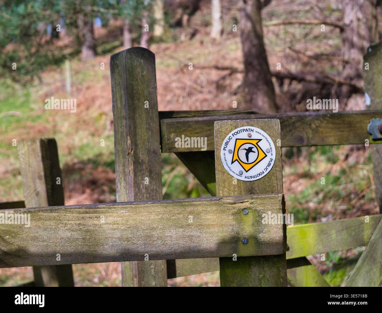 Yorkshire, UK - 14. Mär 2026: Öffentlicher Fußwegweiser, der an einem verwitterten Holztor in Yorkshire UK befestigt ist, mit weichem Waldhintergrund und einer einladenden ländlichen Wanderstimmung Stockfoto