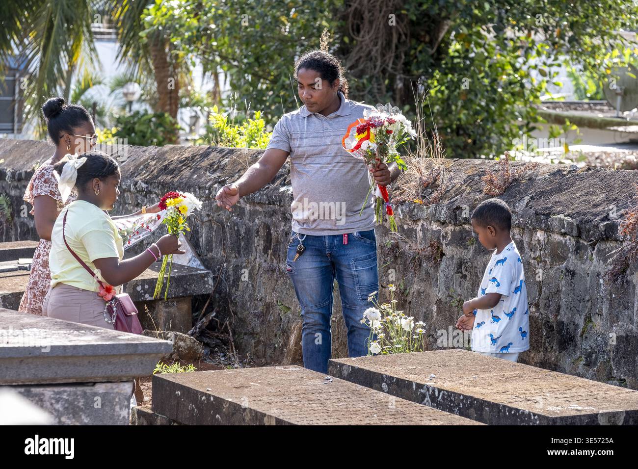 Pamplemousses Friedhof, Mauritius auf La Toussaint, Allerheiligen Tag, Familie, die Blumen auf ein Grab legt Stockfoto