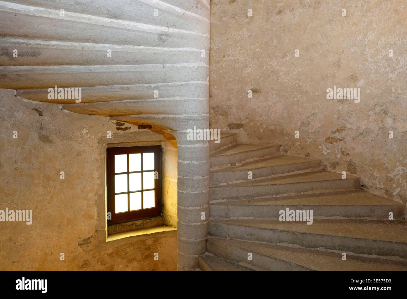 Die glatte Textur des handgeschnitzten Kalksteins verläuft graziös um eine zentrale Newelsäule. Le-Stift. Frankreich. Stockfoto