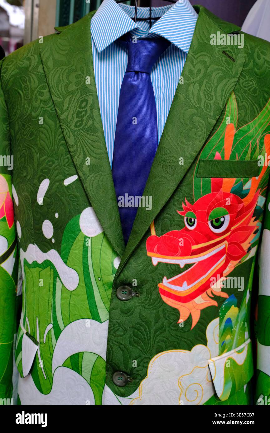 Verzierte grüne Anzugsjacke mit geprägtem Stoff und lebendigem Drachenmotiv zum Verkauf. Vietnam. Stockfoto