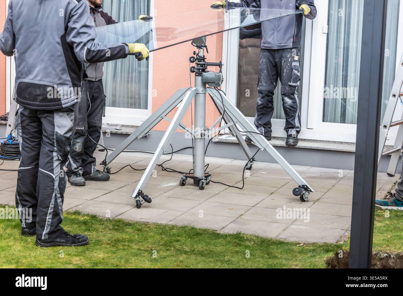 Die Arbeiter installieren Terrassendächer aus Stahl und Glas Stockfoto