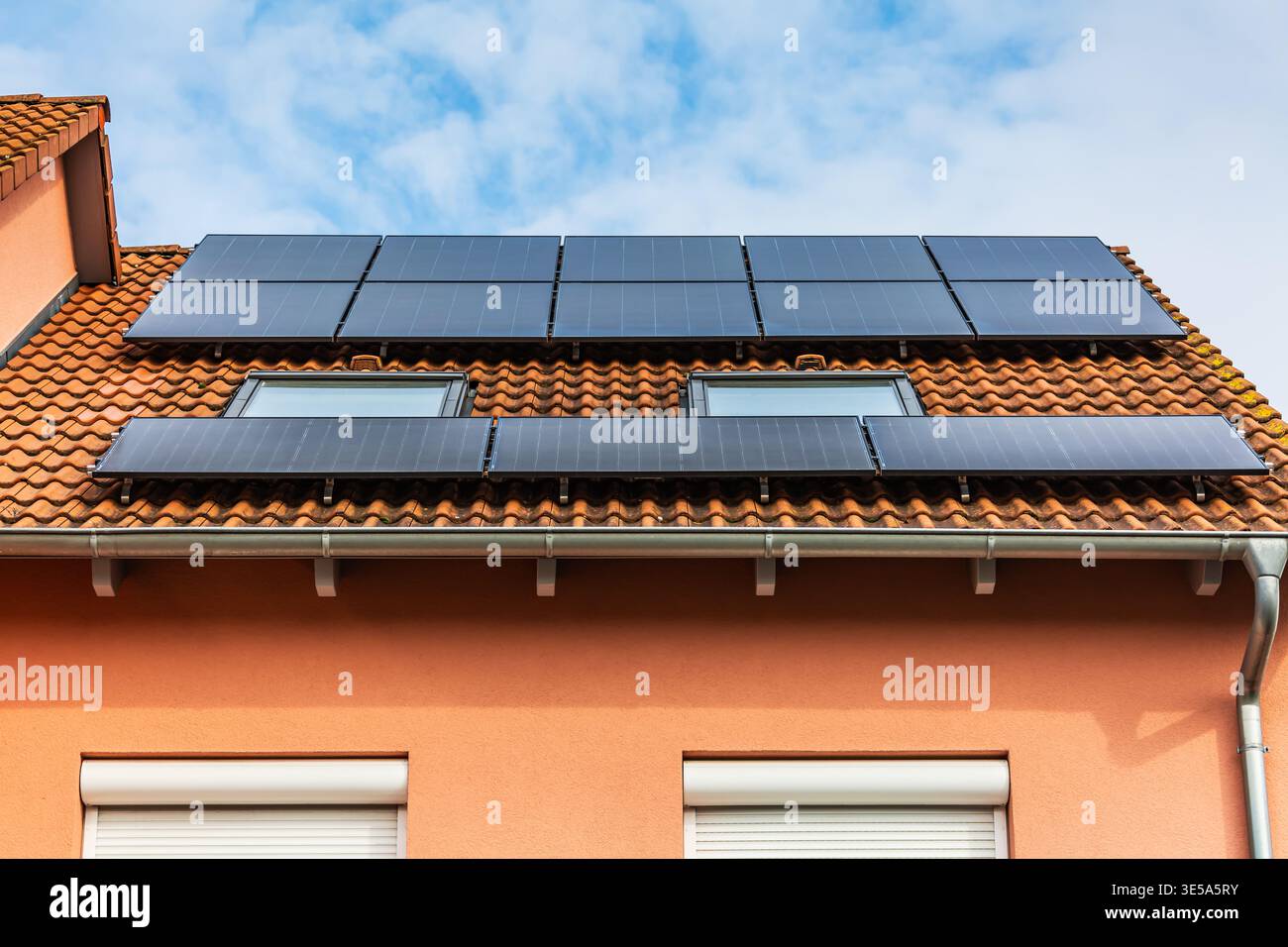 Neue Solarpaneele auf dem Dachblech des modernen Hauses installiert Stockfoto