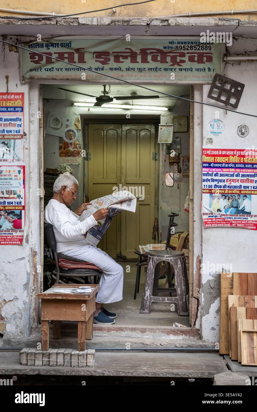 Ein älterer Mann liest eine Zeitung in einer Tür, Jodhpur, Indien Stockfoto