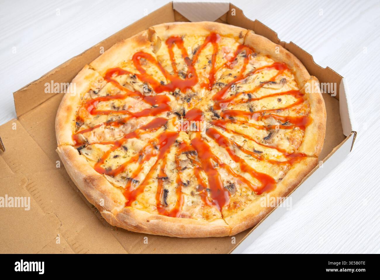 Pizza mit Ketchup, serviert in offener Lieferbox, mit Schwerpunkt auf Fast Food-Service, Take-away-Konzept und Fertigmahlenpräsentation Stockfoto