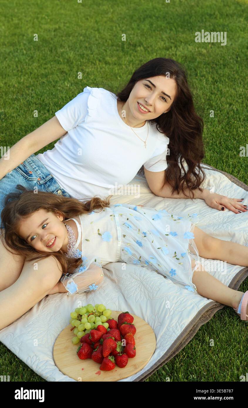 Entspanntes Geburtstagsfest Im Freien, Bei Dem Mutter Und Tochter Früchte Und Freudige Momente Teilen Stockfoto