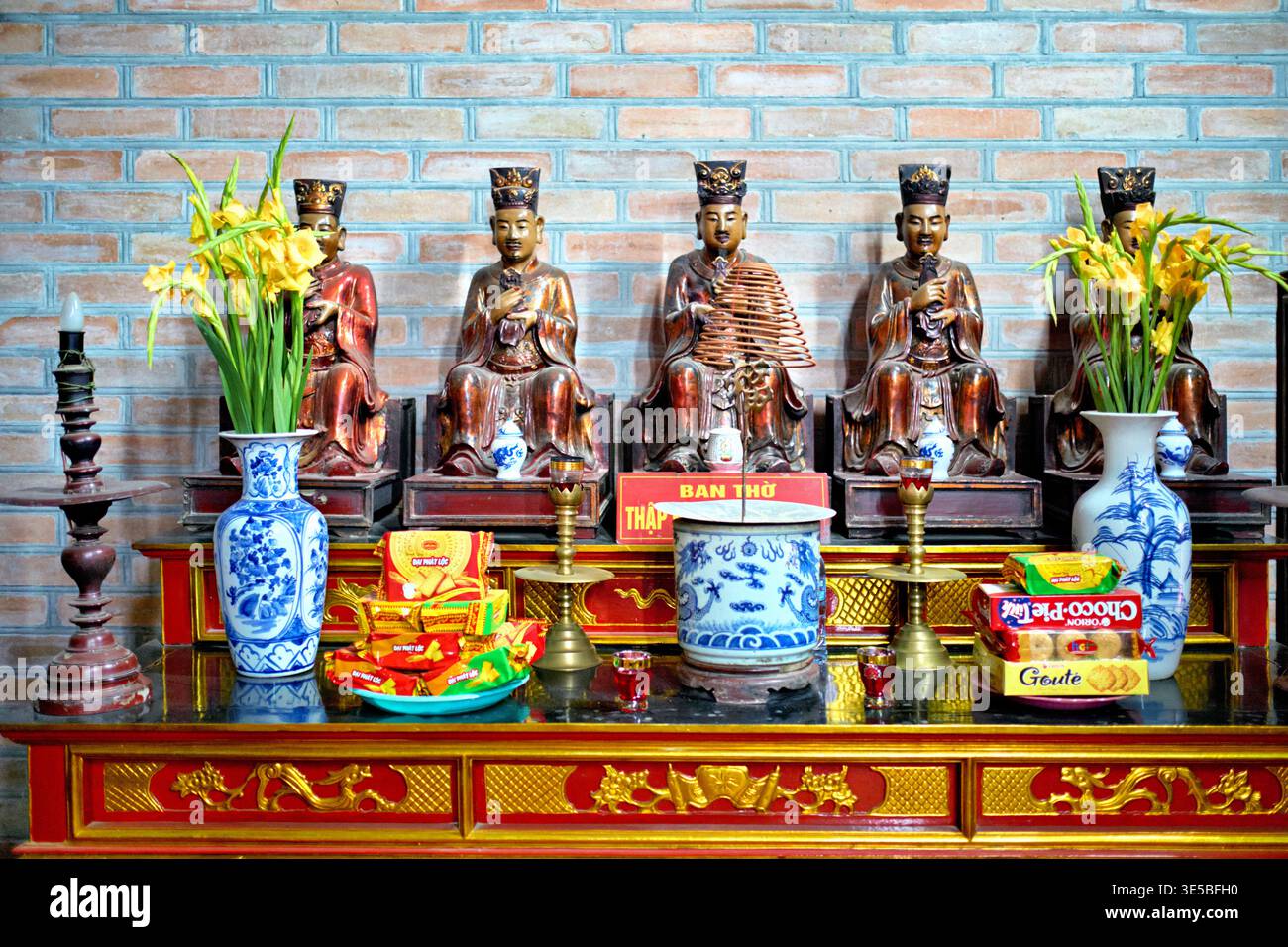 Statuen sind auf dem Altar in Hanoi mit Blumen und Opfergaben für das lokale fest platziert. Menschen besuchen und beten für Glück und Gesundheit. Stockfoto