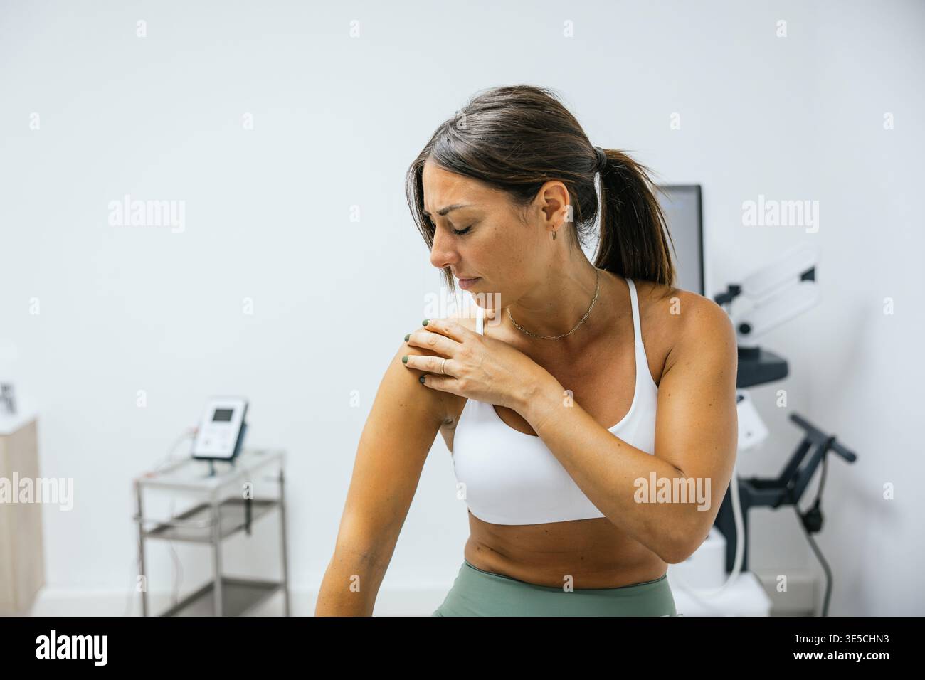 Frau mit Schulterschmerzen während einer physiotherapeutischen Sprechstunde Stockfoto