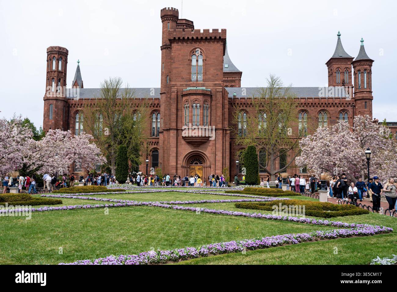 Washington D.C. - 19. März 2025: Eine große Menschenmenge spaziert vor dem Smithsonian Castle in Washington D.C. Stockfoto