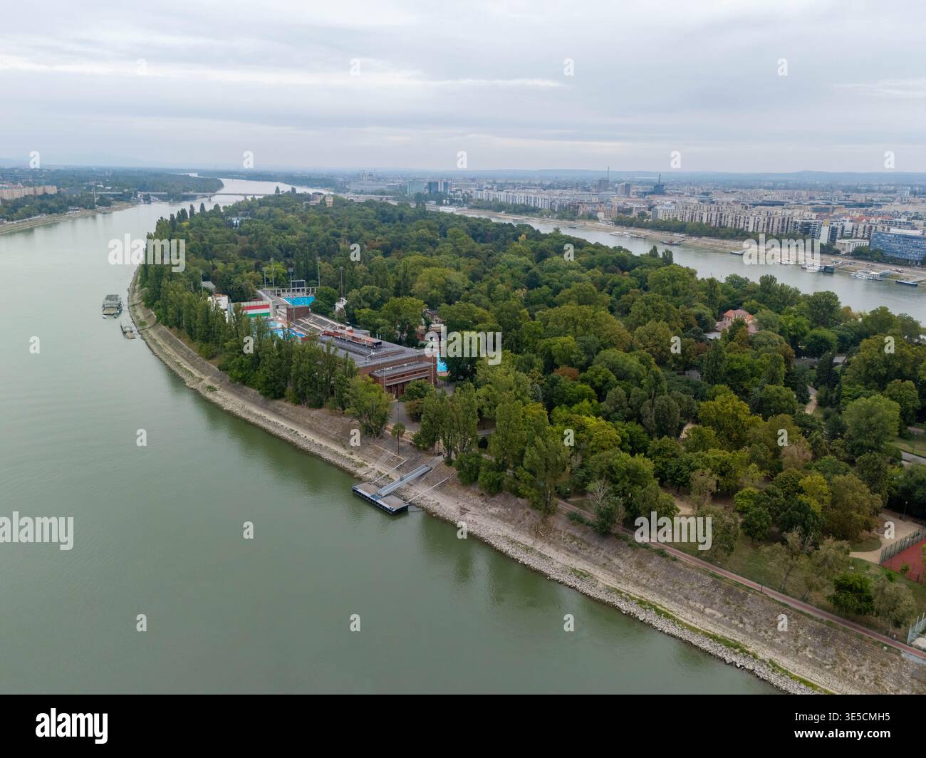 Luftaufnahme der Margareteninsel in Budapest Ungarn an einem bewölkten Tag mit Baumbedeckung entlang der Donau Stockfoto