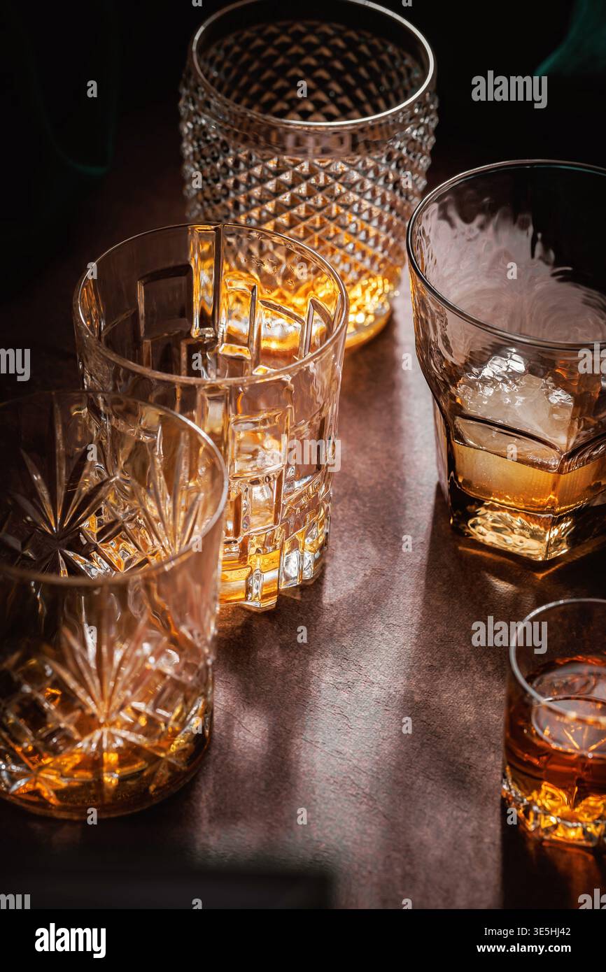 Whiskey-Gläser mit Eis auf Bartisch dramatisches Licht Stockfoto