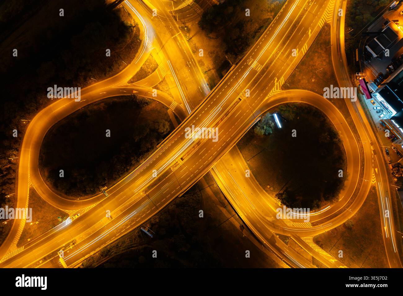 Nächtliche Luftaufnahme des Autobahnkreuzes an der Ausfahrt Spořilov in Prag mit langen Lichtwegen und symmetrischem Straßenverlauf Stockfoto