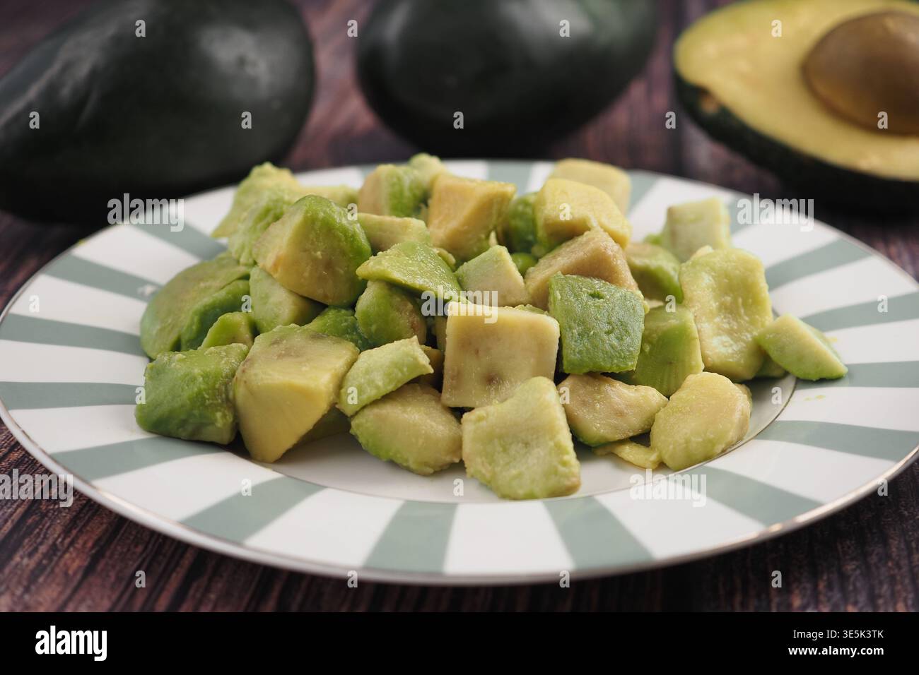 Schneiden Sie Avocadostücke auf einem Teller in der Küche Stockfoto