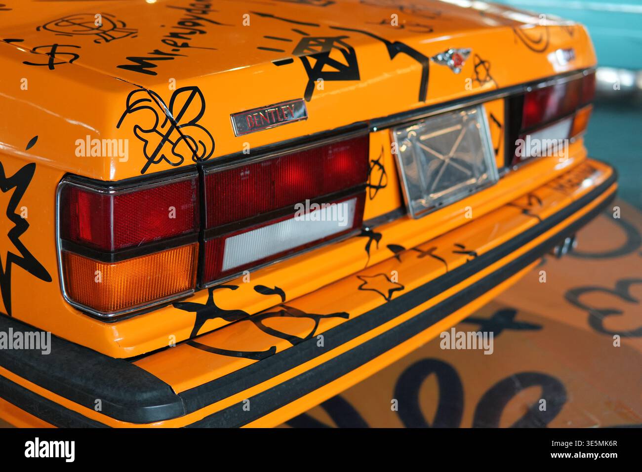 Shanghai 2. märz 2026 Orange Bentley Oldtimer-Heck mit individueller schwarzer Graffiti-Farbe auf dem Kofferraum, auffälliger Urban Art-Optik und klassischem Luxus Stockfoto
