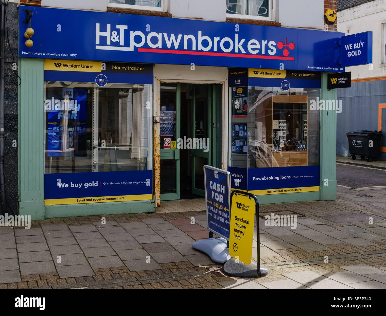H&T Pfandhändler kaufen mit Western Union Geldtransfer-Branding und „We Buy Gold“-Schildern auf der Worthing High Street, West Sussex, England. Straßenwerbung Stockfoto