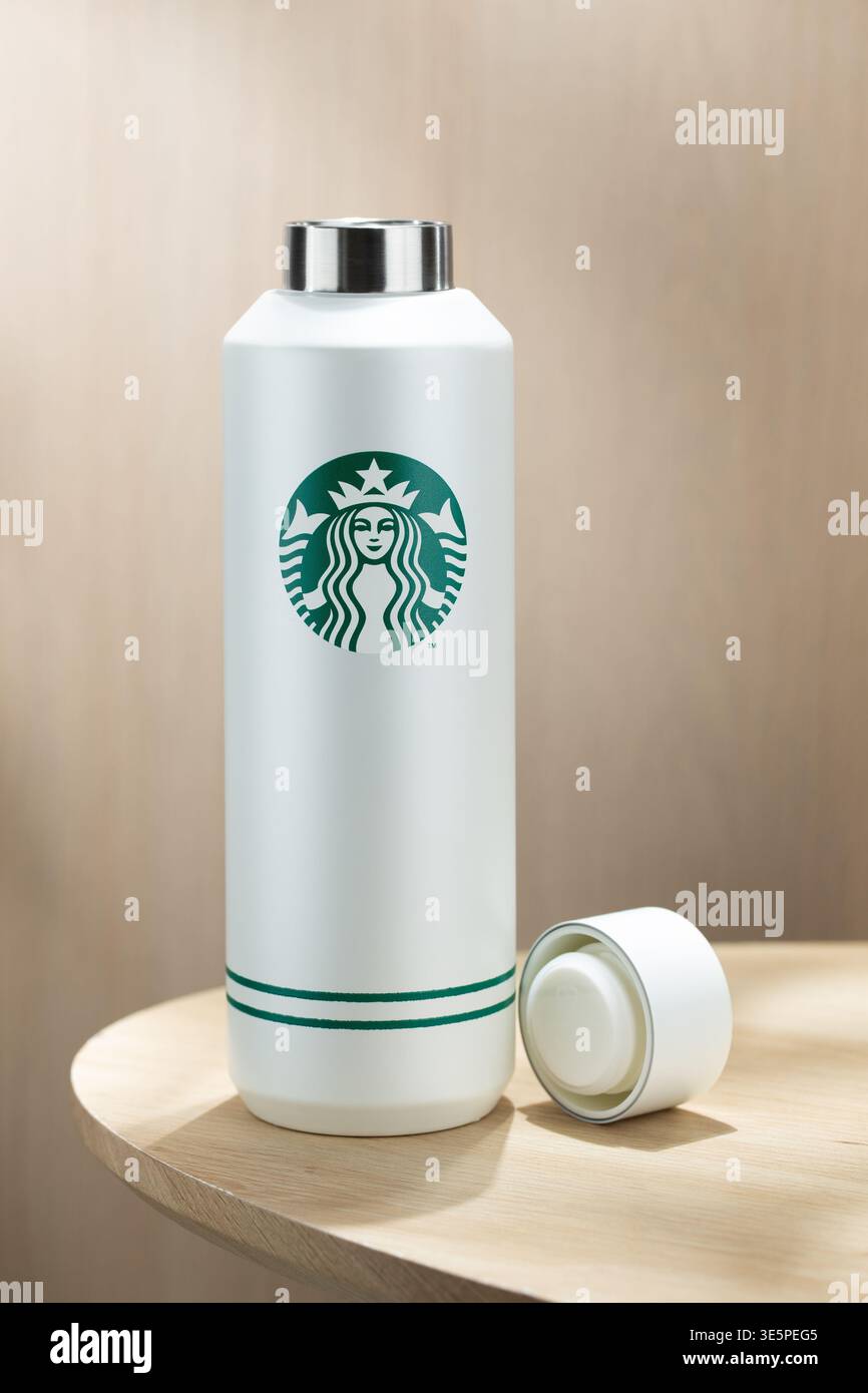 Bangkok Thailand - 2. April 2026: Minimalistische isolierte Flasche mit Starbucks-Logo auf einem Holztisch, sauberer Hintergrund, modernes Lifestyle-Konzept Stockfoto