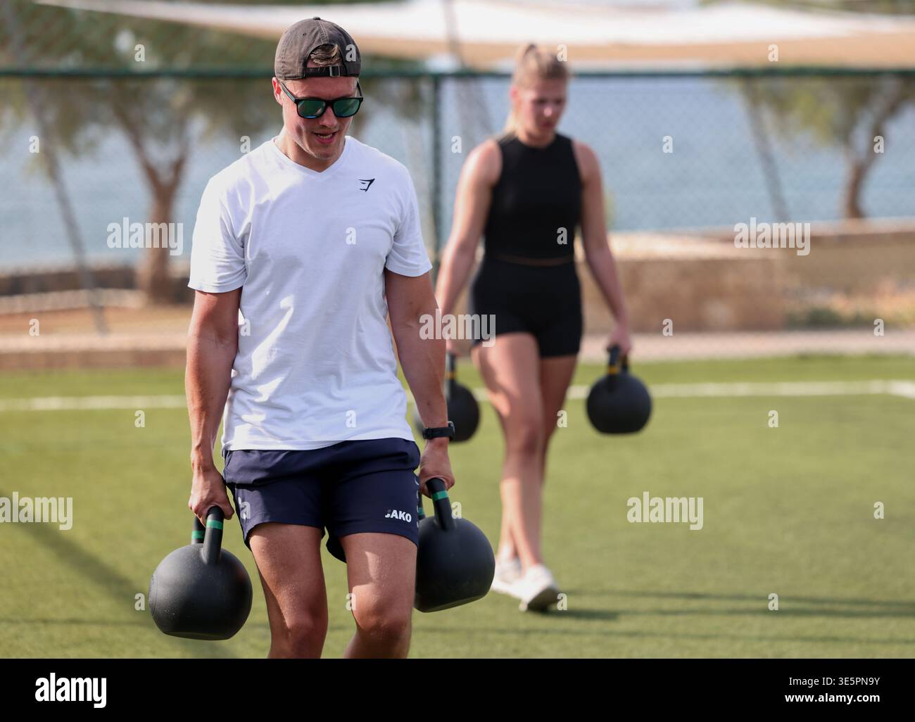 Zwei Athleten mit Kesselglockengewichten während des Hyrox Camp im Kalimera Kriti Hotel & Village Resort, Sissi, Kreta, Griechenland. Stockfoto