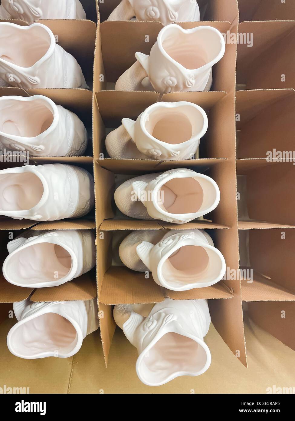 Reihen von Wasserkannen aus weißer Keramik, die Kabeljau gurgeln, verpackt in einem Karton für Transport und Verteilung von Wasserkeramik, Stake on trent - Smartphone-aufgenommenes Stockfoto