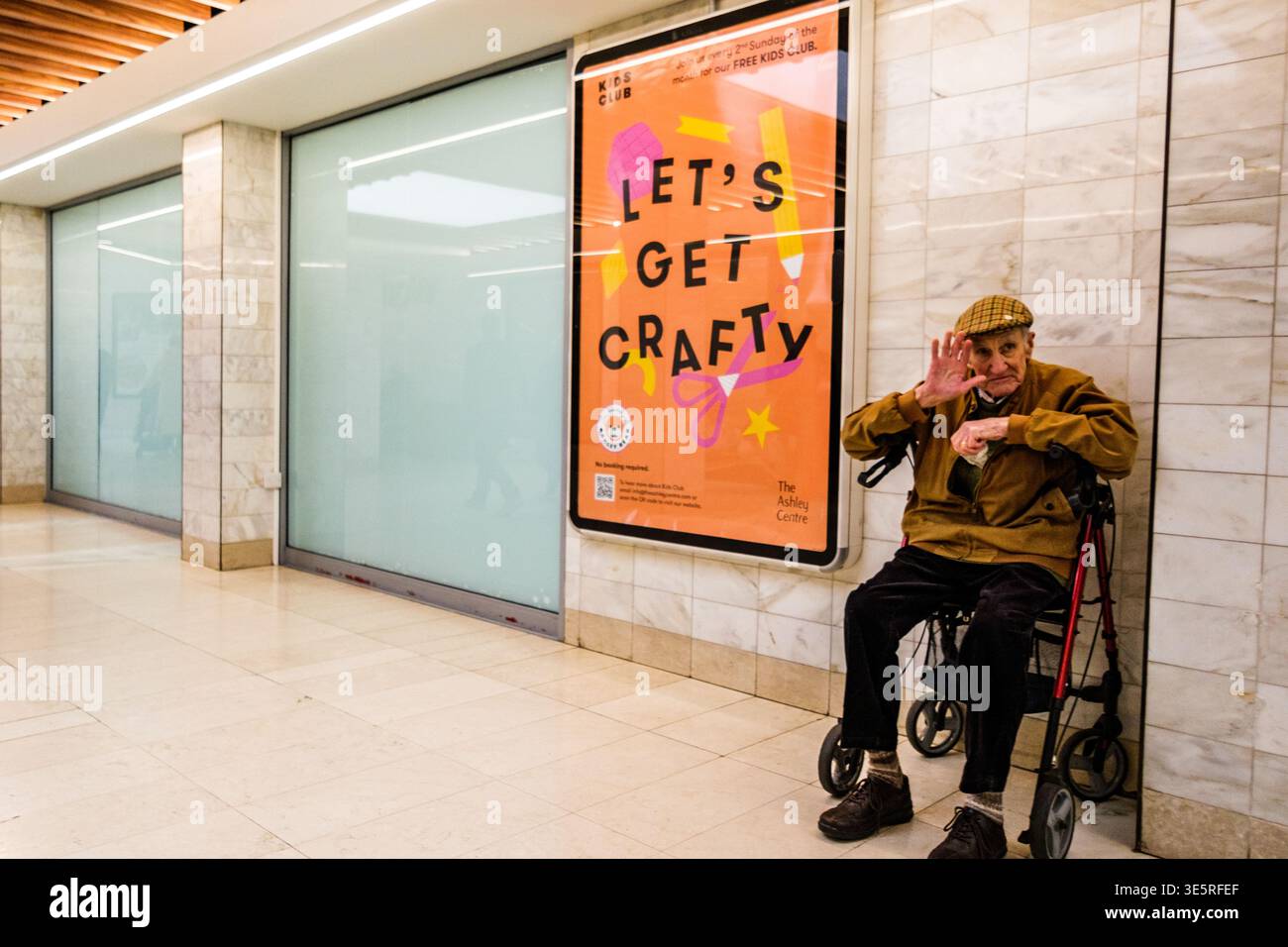 London UK, 2. April 2026, ein alter Senior Mann, der allein in seinem Walking Frame Rollator in einem leeren Einkaufszentrum sitzt Stockfoto