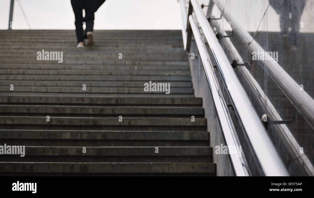 Person, die Treppen in der Stadt klettert, Konzept des Fortschritts, Wachstum und Vorwärtsbewegung Stockfoto