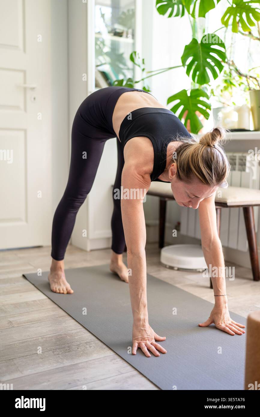 Gesunde reife Frau, die sich um Körper und Gesundheit kümmert, Fitness-Training zu Hause. Stockfoto