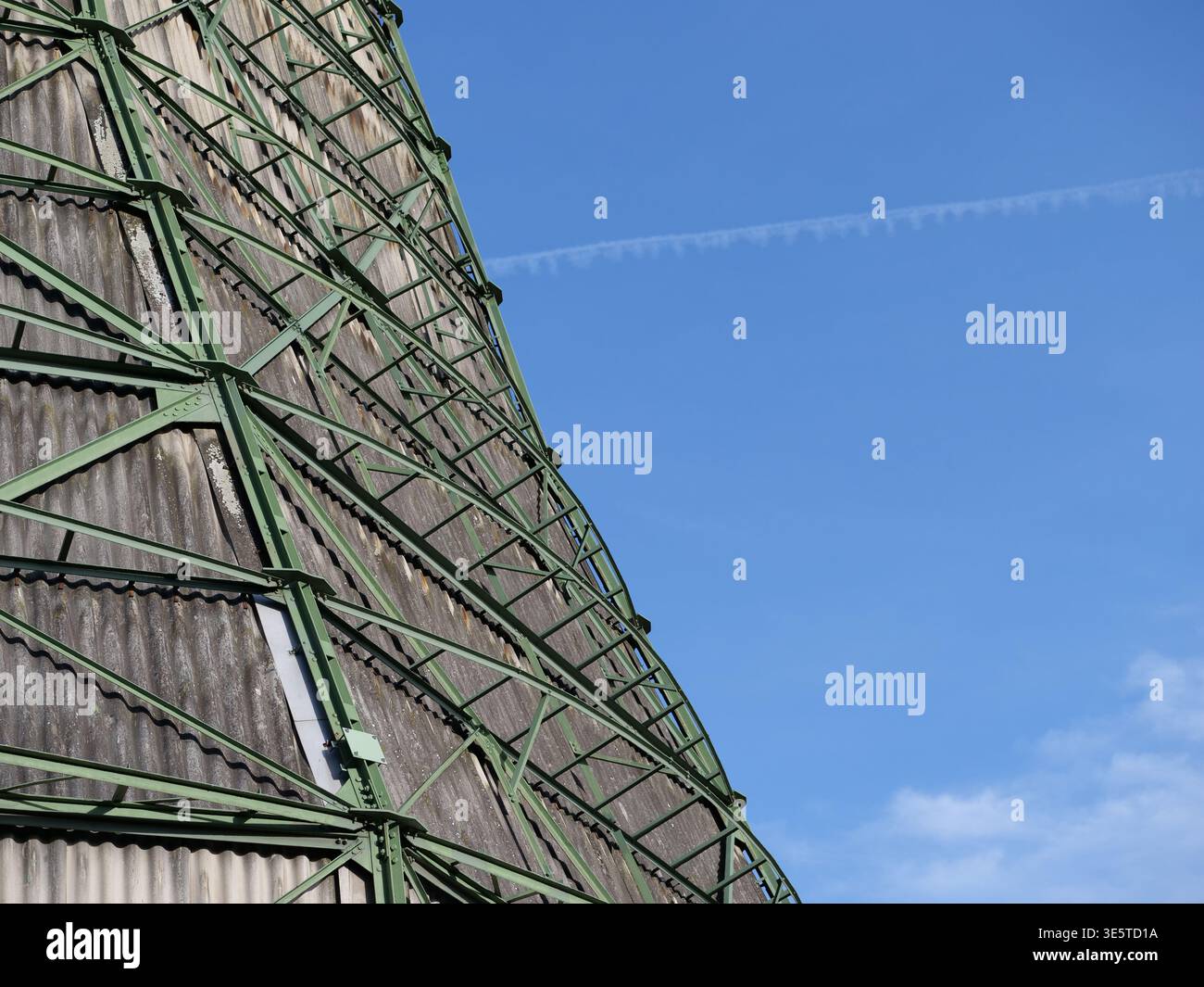 Nahaufnahme eines alten industriellen Kühlturms mit grünem Metallgerüst und grauer Wellholzverkleidung. Tiefwinkelansicht eines Kraftwerks Stockfoto