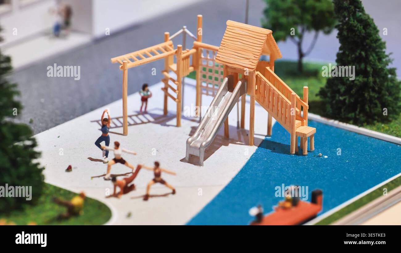 Miniatur-Welt, die Modellfiguren beim Yoga in einem Spielplatzkonzept zeigt Stockfoto