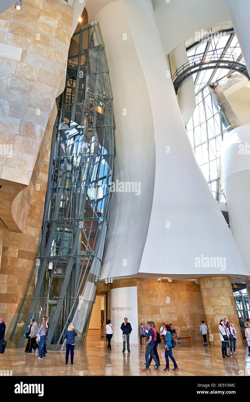 Die Menschen laufen in das Guggenheim Museum in Bilbao, Spanien. Sie bewundern die einzigartige Architektur und das Design. Es ist ein arbeitsreicher Tag. Stockfoto
