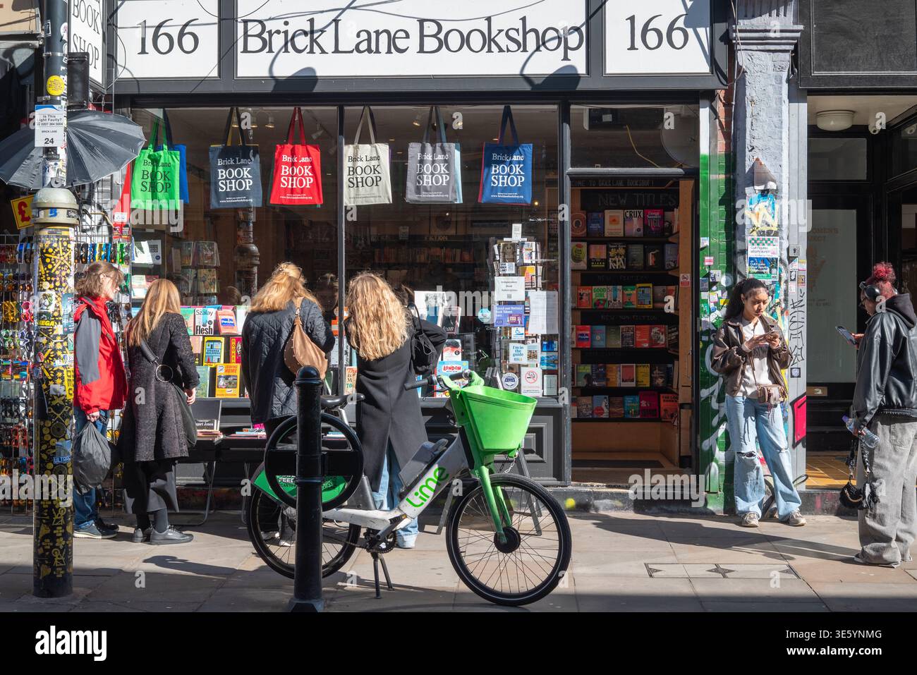 Leute, die vor dem Brick Lane Bookshop in London, Großbritannien, Bücher durchsuchen Stockfoto